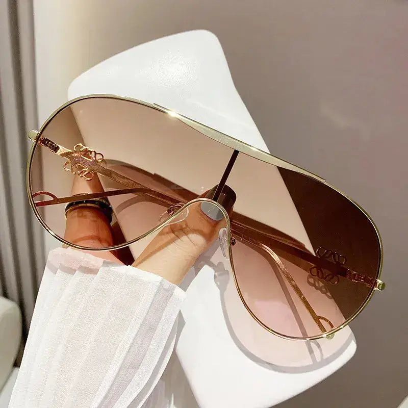 Gradient Aviator Sunglasses held in hand showing UV400 protection and stylish design.