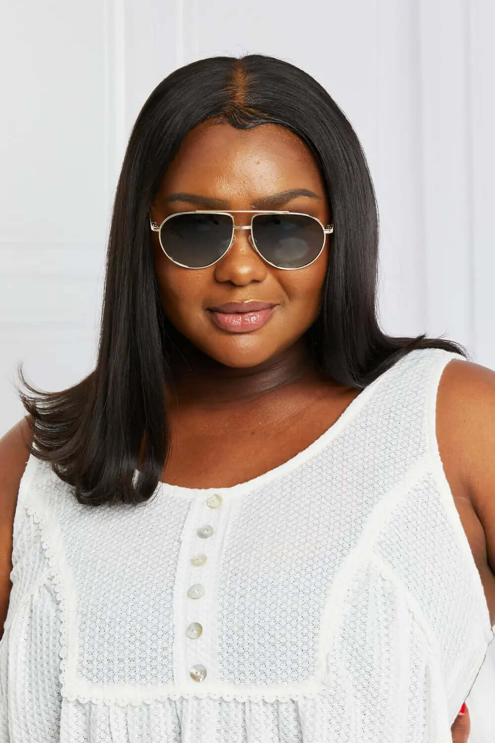 Woman wearing TAC Polarization Lens Aviator Sunglasses with a white top and long straight hair.