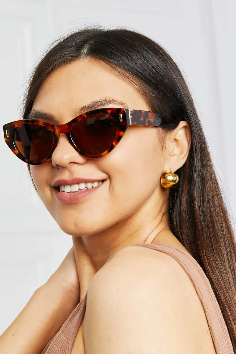 Tortoiseshell Acetate Frame Sunglasses worn by a woman, showcasing the cat eye design and stylish look.